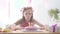 Caucasian girl is dreamily smiling and looking at birthday rainbow cake. Festive colourful background with balloons