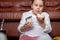 caucasian girl is eating Unhealthy sweet cakes and watching tv sitting on floor.