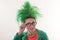 A caucasian girl in a green dress and with green hair is preparing for the holidays. Suit of the teacher of primary classes. The c