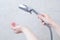 Caucasian girl holding a shower watering can. Jets of water on hand.