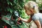 Caucasian girl looking at plants flowers anthurium through magnifying glass