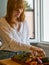 Caucasian girl in a modern kitchen, prepares some vegetables