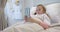 Caucasian girl patient lying in hospital bed using smartphone, copy space, slow motion