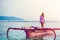 Caucasian girl posing standing on a pink boat in the sea at sunset .on the island of Gili