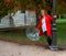 Caucasian girl with red coat plays with transparent umbrella next to a lamppost