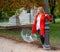 Caucasian girl with red coat plays with transparent umbrella next to a lamppost