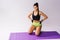 Caucasian girl resting on yoga mat between sports exercises. Good physical fitness and proper nutrition on a white