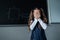 Caucasian girl stands at the blackboard and cries covering her face with her hands. The schoolgirl did not prepare for