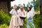 Caucasian Girls Together in Traditional Rural Dress With Basin of Linens Outdoors