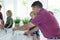 Caucasian grandfather in bathroom brushing teeth with grandson sitting beside basin