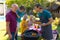 Caucasian grandfather, father and son barbecuing meal together in garden