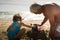 Caucasian grandfather and granddaughter playing together on the beach