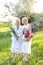 Caucasian granny in white dress with daughter and granddaughter outside.