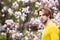 Caucasian guy with beard in yellow sweater on floral background