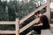 caucasian guy with long collected hair with beard and t-shirt sitting calm and relaxed on the stairs of the viewpoint