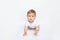 Caucasian hairy baby boy in white t-shirt crawls on all fours on white background