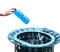 Caucasian hand throwing a bottle of water made of blue plastic into a wastepaper basket