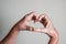 Caucasian hands with vitiligo skin disorder forming a heart with fingers on isolated background