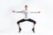 Caucasian Handsome Young Man Dancing Ballet Posing in Stretching Pose with Lifted Hands in White Shirt On White