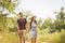 Caucasian hipster couple walking along path in countryside. man with beard holds the hand of his beloved girl while hiking in