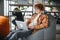 Caucasian hipster guy enjoying distance job in coffee shop, male freelancer in trendy glasses sitting in cafeteria with