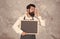 Caucasian hipster male cook with satisfied look showing perfection gesture holding empty blackboard advertising culinary