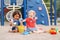 Caucasian and hispanic latin babies children sitting in sandbox playing with plastic colorful toys