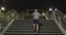 Caucasian hooded male doing sport in a street in the evening