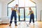 Caucasian janitors in uniform mopping floor together