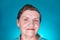 Caucasian kind grandmother looking at camera. Portrait of smiling aged woman in studio on blue background.