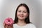 Caucasian litlle Girl in white T-shirt Holding Donut with pink glaze on white background