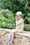 Caucasian Little Blond Girl Walking Tropical Garden