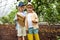 Caucasian little brothers hold map or fruit list in the garden