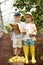 Caucasian little brothers hold map or fruit list and magnifier in garden