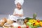 Caucasian Little Girl In Cook Uniform With Fresh Eggs and Saucepan