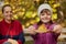 Caucasian little girl leaf boat to camera, posing with her mother on background, admires nature, happy child in pink cap and