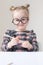 Caucasian little girl with round glasses. Little teacher