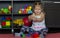 Caucasian little girl of three years old smiling because of crashing her pyramid made of colorful stacking cups