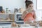 Caucasian little kid girl enjoy eating slice of fresh baked whole wheat bread at kitchen in morning. Cute child mess up with flour