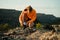 Caucasian male athlete taking a break tying shoe lace while running in wilderness mountain at sunset