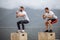 Caucasian male athletic friends doing box jump outdoor on top of the mountain.