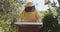 Caucasian male beekeeper in protective clothing opening beehive