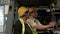 Caucasian male and black female engineers in safety uniforms and helmets on the forklift. Two employees taking about stock order o