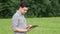 The caucasian male brunette farmer on the field works with a tablet. Scientist working in the field with agricultural