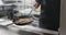 Caucasian male chef frying vegetables in a pan in kitchen, slow motion