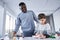 Caucasian male child using human body anatomy puzzle toy while playing with his multiracial father