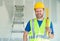 Caucasian Male Contractor With Hard Hat, Level and Safety Vest At Construction Site