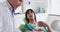 Caucasian male dentist examining teeth of female patient at modern dental clinic