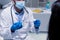 Caucasian male doctor wearing face mask and gloves preparing vaccine for patient