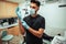 Caucasian male doctor wearing surgical mask and gloves standing in doctors office ready to operate